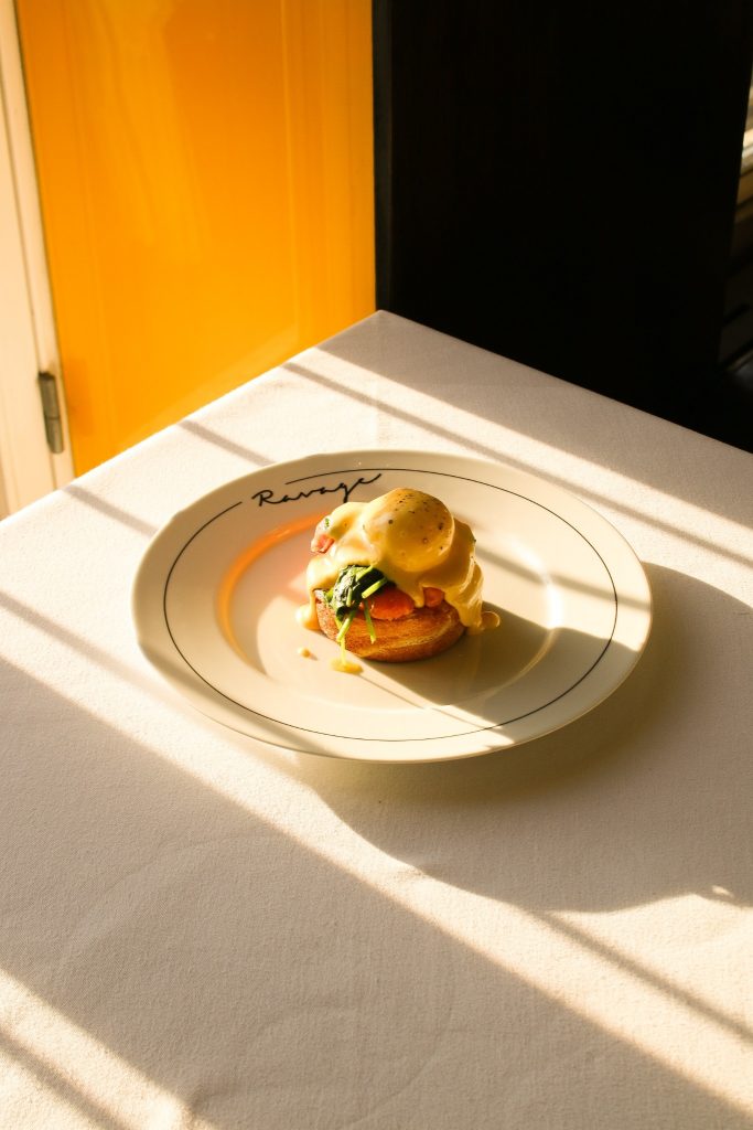 Eggs Benedict serveret på Ravage i varmt sollys.